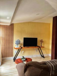 a living room with a couch and a flat screen tv at Espaço Augusto in Barreirinhas