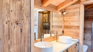 two sinks in a bathroom with wooden walls at Agane skis aux pieds jacuzzi et vue montagne in Les Angles