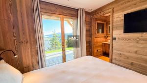 a bedroom with a bed and a large window at Agane skis aux pieds jacuzzi et vue montagne in Les Angles