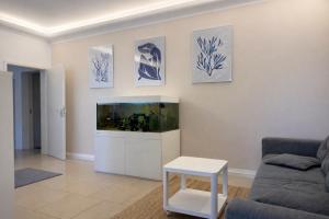 a living room with a fish tank on a wall at FRAME by Tendo Stay - Comfort Housing in Falkensee