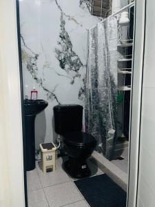 a bathroom with a black toilet and a shower at Vista colonial suite in Comayagua