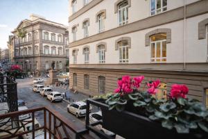 a balcony with pink flowers on a city street at Mamalu - Corso Umberto 35 - Studios and Suites in Naples