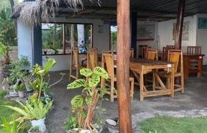 a restaurant with a wooden table and chairs at East Lombok Dive Hotel - Rooms on the beach with seaview in Labuhanpandan