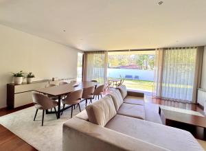 a living room with a couch and a table and chairs at Villa Branco - Private Pool & Garden in Barcelos