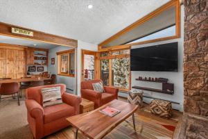 a living room with a large television and a table at Shadowbrook 303 in Snowmass Village