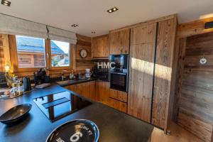 a kitchen with wooden cabinets and a counter top at Bliss luxe pyrénéen jacuzzi et vue montagne in Bolquere Pyrenees 2000 +24 photos