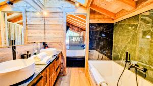 a bathroom with a tub and a sink and a bath tub at Ski Bob accès direct pistes jacuzzi privé in Bolquere Pyrenees 2000 +15 photos