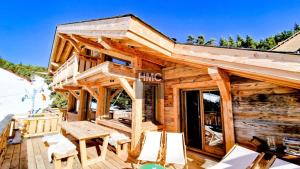 a log cabin with a picnic table on a deck at Ski Bob accès direct pistes jacuzzi privé in Bolquere Pyrenees 2000