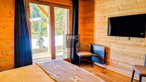 a bedroom with a tv on a wooden wall at Ski Bob accès direct pistes jacuzzi privé in Bolquere Pyrenees 2000