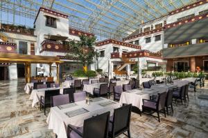 a restaurant with tables and chairs and a glass ceiling at InterContinental Lhasa Paradise by IHG in Lhasa