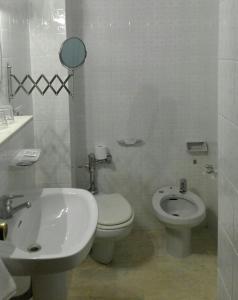 a white bathroom with a toilet and a sink at Moncl&uacute;s in Palencia