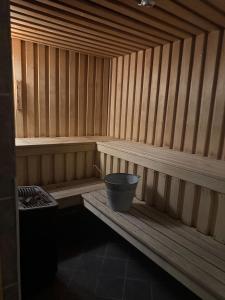 a small wooden sauna with a bucket in it at Oppheim Resort - Pool, Sauna & Lake! in Vossevangen