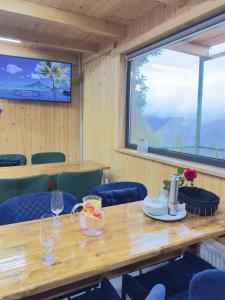 a dining room with a table and chairs and a window at Гойра in Verkhniy Yasenov