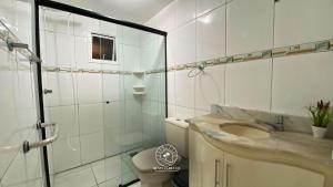 a bathroom with a toilet and a sink and a shower at Casa centro de Torres – 500 mts do mar in Torres