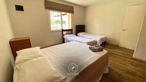 a room with two beds and a window at Casa centro de Torres – 500 mts do mar in Torres