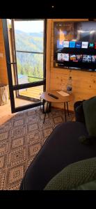 a living room with a table and a large window at Гойра in Verkhniy Yasenov