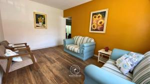 a living room with two chairs and a couch at Casa centro de Torres – 500 mts do mar in Torres