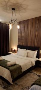 a bedroom with a large bed with a wooden headboard at Illy Apartament in Gjakove