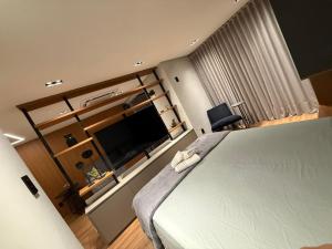 a bedroom with a bed and a flat screen tv at Studio Aconchegante no Number One Flat com vista mar in São Luís +21 photos