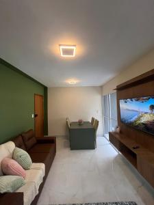 a living room with a couch and a flat screen tv at Impera House Terreo Ar nos 2 quartos in Imperatriz