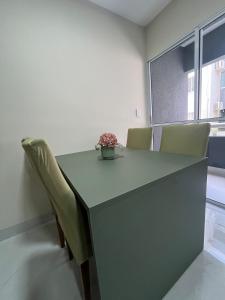 a table with chairs and a vase of flowers on it at Impera House Terreo Ar nos 2 quartos in Imperatriz