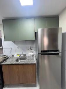 a kitchen with a stainless steel refrigerator and a sink at Impera House Terreo Ar nos 2 quartos in Imperatriz +23 photos