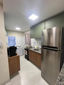 a large kitchen with a stainless steel refrigerator at Impera House Terreo Ar nos 2 quartos in Imperatriz