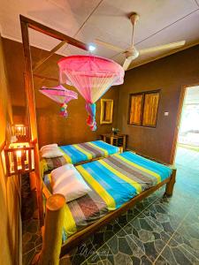 a bedroom with a bed with umbrellas hanging from the ceiling at Elephant paradise Safari lodge in Udawalawe
