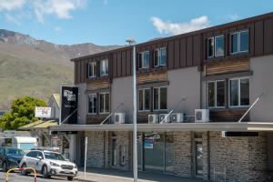 a building with cars parked in front of it at The Brownston Hostel in Wanaka