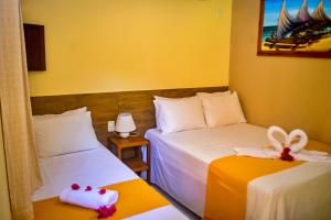 two beds in a room with yellow walls at Pousada Sitio Araça in São Miguel dos Milagres +15 photos