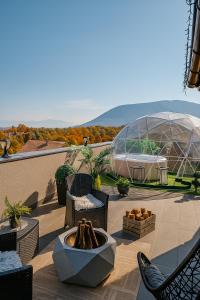 a patio with a table and chairs and a glass dome at Villa Kaplan Sarajevo in Gladno Polje