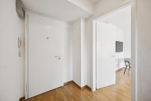 an open door to a room with white walls and wooden floors at Very centrally located studio - Crown 15 in Zurich