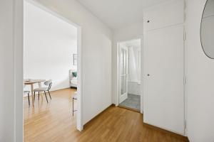 a white apartment with a dining room and a table at Very centrally located studio - Crown 15 in Zurich