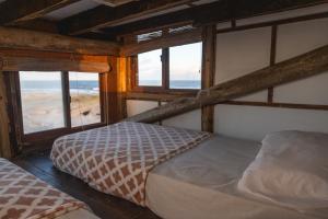 a bedroom with two bunk beds and a view of the ocean at Narakan Cabo Polonio in Cabo Polonio