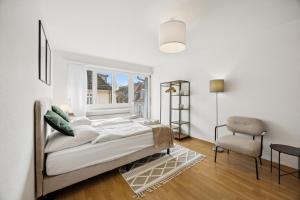 a bedroom with a bed and a chair and a window at Very centrally located studio - Crown 15 in Zurich