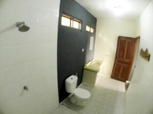 a bathroom with a toilet and a window and a door at East Lombok Dive Hotel - Rooms on the beach with seaview in Labuhanpandan +42 photos
