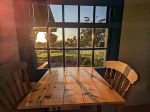 a wooden table with two chairs in front of a window at Jay's Cabin in Skibbereen +8 photos
