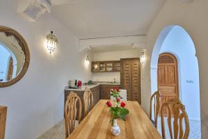 a kitchen with a wooden table with a vase of flowers on it at La Douiria Essaouira Medina in Essaouira
