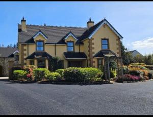 a large yellow house with bushes in front of it at Shamrock House in Fintona