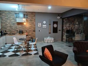 a kitchen and a living room with a table and chairs at Casa com piscina aquecida, estilosa e privativa in Nazaré Paulista