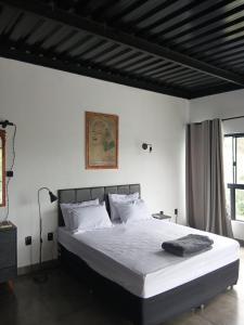 a bedroom with a large bed with white sheets at Casa com piscina aquecida, estilosa e privativa in Nazaré Paulista +84 photos