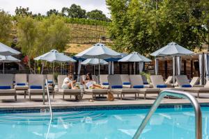 two people sitting on lounge chairs next to a swimming pool at The Meritage Resort and Spa in Napa