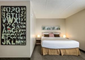 a bedroom with a large bed and a painting on the wall at Heritage Inn Hotel & Convention Centre - Taber in Taber