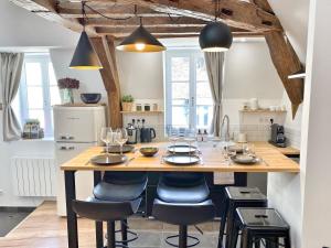 a kitchen with a large wooden island with bar stools at Le Repères des sommeliers - Bail Partner in Auxerre