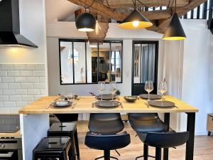 a kitchen with a table with chairs and wine glasses at Le Repères des sommeliers - Bail Partner in Auxerre