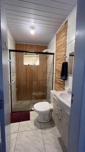a bathroom with a shower and a toilet and a sink at Pousada Chalés Beach - Praia do Rosa in Praia do Rosa +35 photos