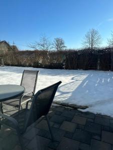 two chairs and a table in a yard with snow at Studio Apartment - Neufelden in Neufelden +1 photo