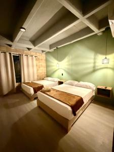 a bedroom with two beds and a green wall at Aira Hotel in Coveñas +10 photos