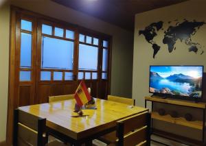 a dining room with a table and a tv at Cabañas Ventalia in El Calafate