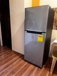 a refrigerator with a yellow sticker on it in a room at DC Travellers Inn in Malolos